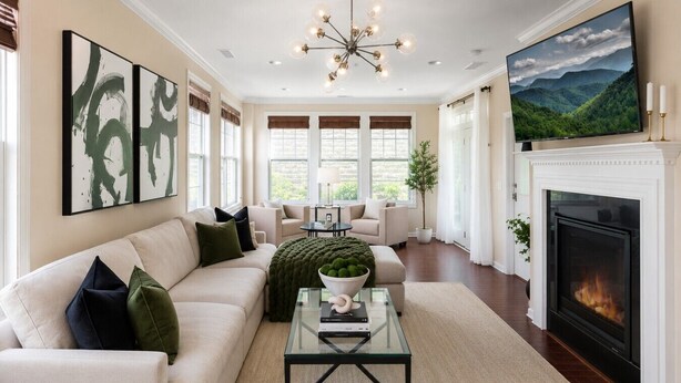 A living room with a sofa, coffee table, fireplace, and artwork on the wall.
