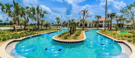 A pool area with multiple lanes, palm trees, and a building in the background.