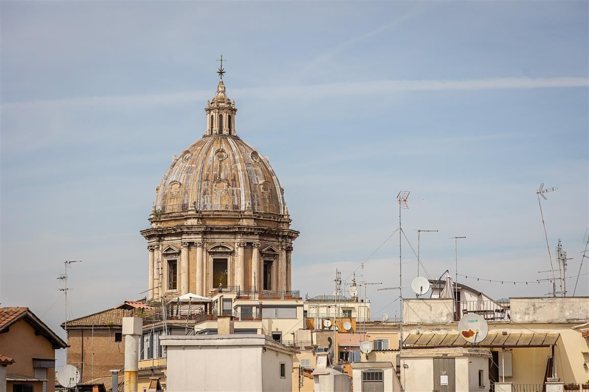 A historic building with a dome, surrounded by urban structures.