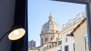 A view of a historic building with a dome and a bell tower through a window.