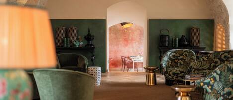 A cozy interior with a fireplace, green walls, and comfortable seating.