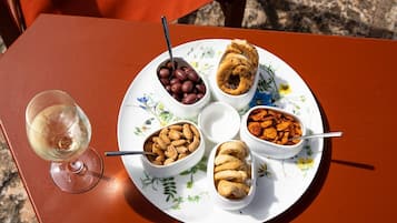 A table with a plate of food and a glass of wine.