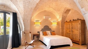 Ein Schlafzimmer mit einem großen Bett, einem Holzschrank, einem Sessel und einem Tisch.