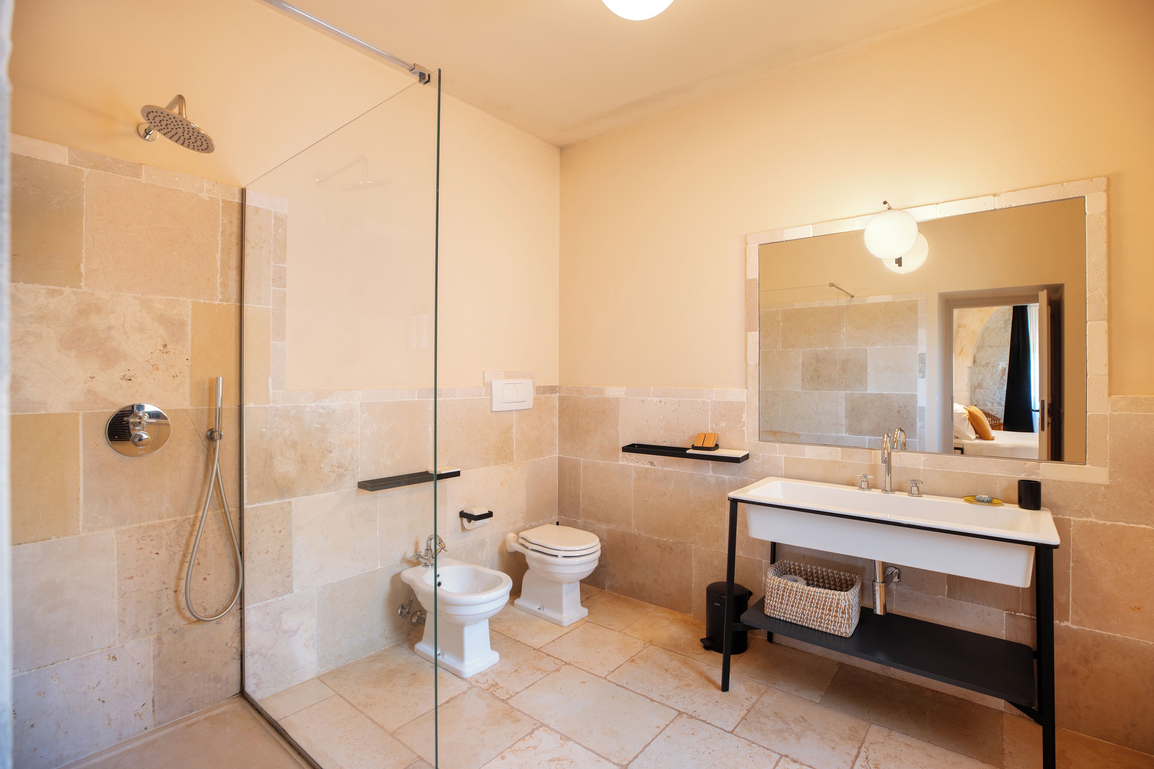A modern bathroom with a glass shower enclosure, a white toilet, and a vanity with a mirror.