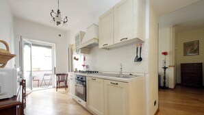 A kitchen with white cabinets, a built-in oven, and a sink.