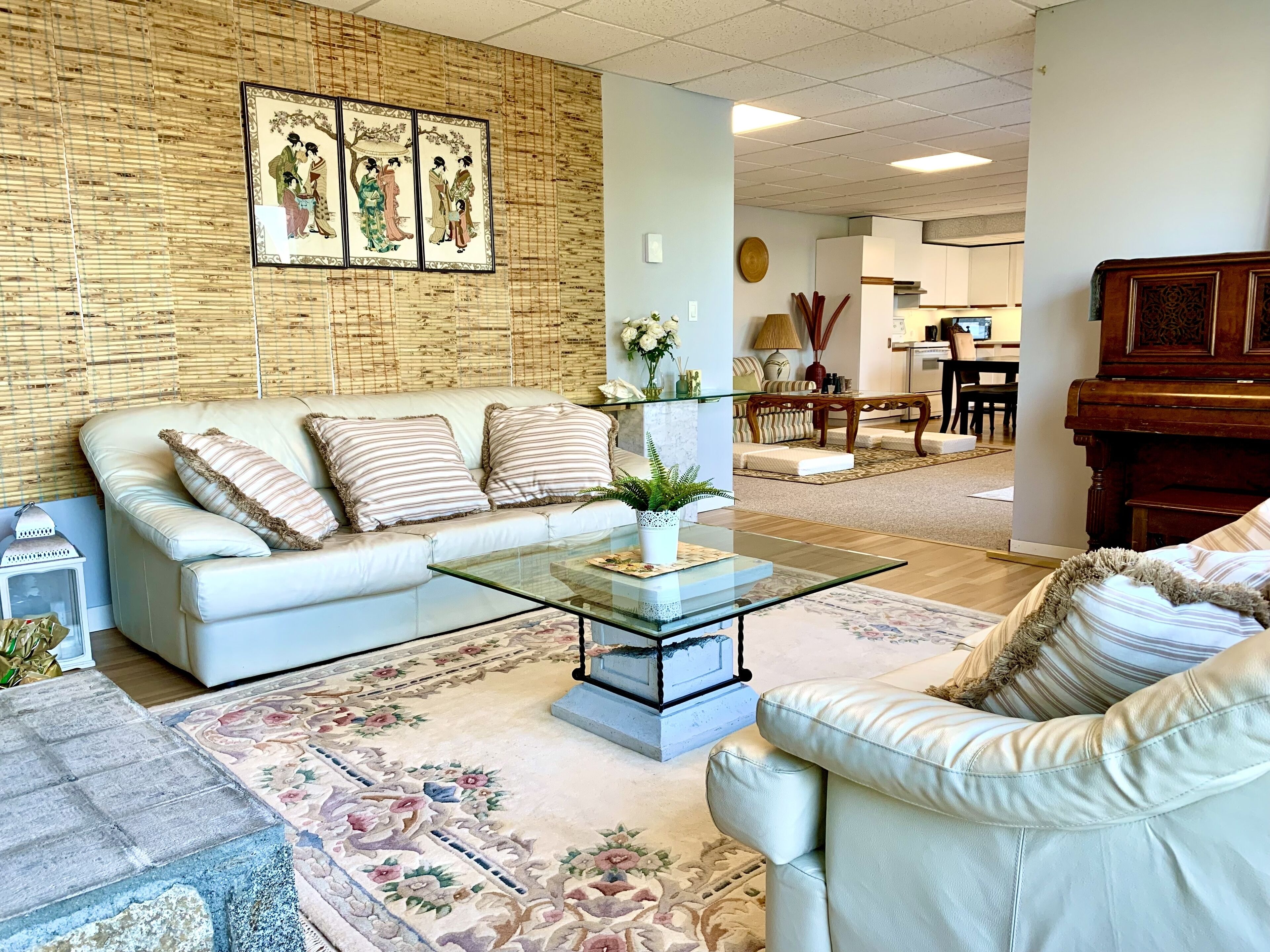 A living room with a sofa, coffee table, and a piano.