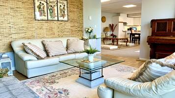 A living room with a sofa, coffee table, and a piano.