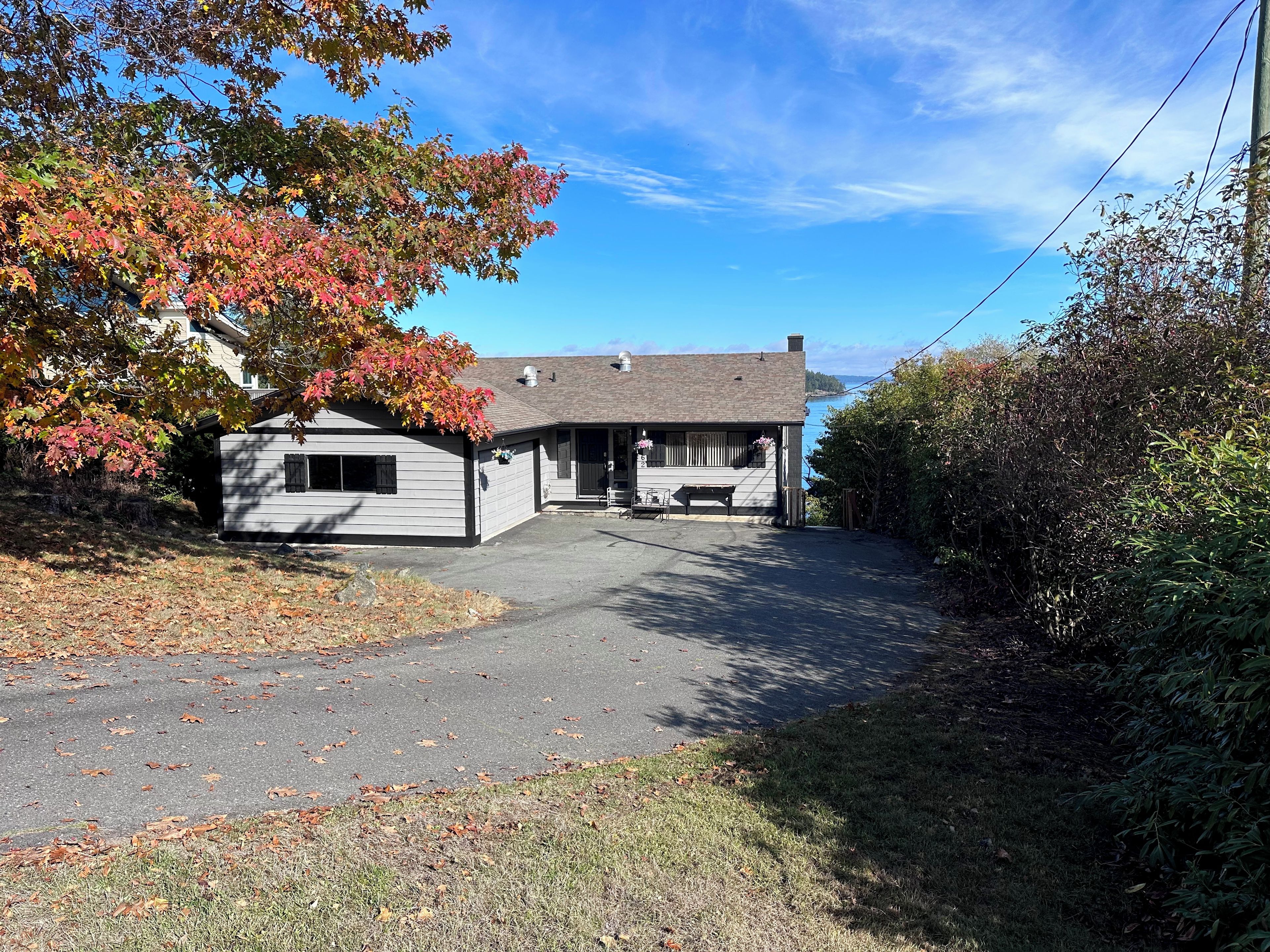 A two-story building with a covered porch and a small attached structure.