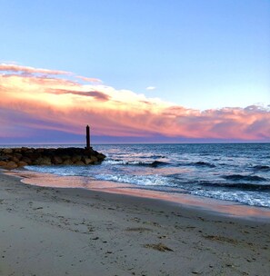 Una playa con un rompeolas rocoso y olas.