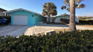 A residential property with a garage, a palm tree, and a well-maintained lawn.