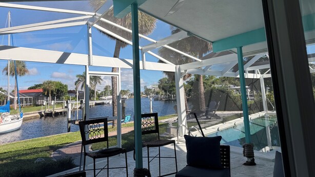 A covered outdoor area with chairs and a view of a water body.