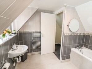Une salle de bain moderne avec un lavabo, des toilettes et une baignoire.
