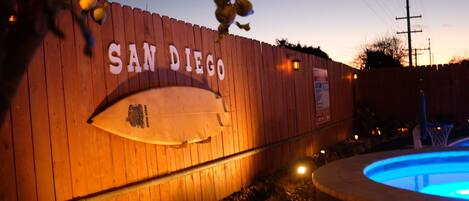 Pared de madera con el texto “SAN DIEGO” y un gráfico de tabla de surf.
