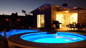 A swimming pool with a circular design, surrounded by a patio area with outdoor furniture. - Prime Location: Lux 4BR w Pool/Spa/Cabana/Firepit (San Diego)