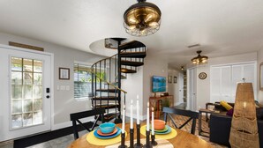 A dining area with a wooden table, colorful plates, and candles. - 1- King bed/ 1- sofa bed/ 1.5bath Block from Beach (Cocoa Beach)