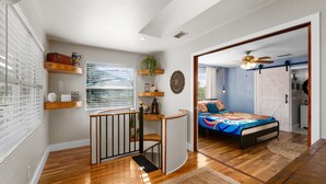 A bedroom with a bed, a staircase, and a view of the outside. - 1- King bed/ 1- sofa bed/ 1.5bath Block from Beach (Cocoa Beach)