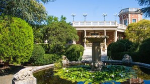 A garden with a fountain, a building with columns, and a clear sky. - Villa Rosa Resort - House 9 (Conversano)