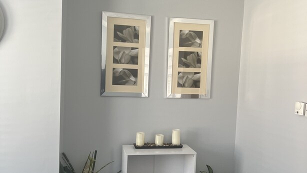 A corner room with grey walls, a white ceiling, and a white shelf with three candles. There are two potted plants, one on each side of the shelf. - Spacious 1-bed Apartment in the Heart of Herne Bay (Herne Bay)
