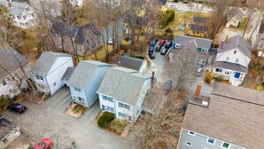 An aerial view of a residential area with houses, parked cars, and a clear sky. - Heart of Downtown Bar Harbor - fully airconditioned (Bar Harbor)