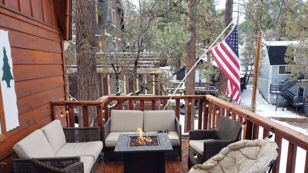 A wooden deck with outdoor seating, a fire pit, and an American flag. - BIG BEAR HIDEAWAY- 3 BED 2 BATH PRIVATE CUL-DE-SAC (Big Bear)