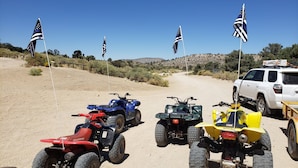 A dirt road with four ATVs and a white SUV parked on the side. - BIG BEAR HIDEAWAY- 3 BED 2 BATH PRIVATE CUL-DE-SAC (Big Bear)