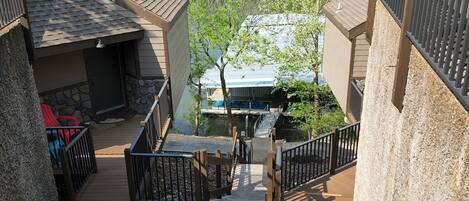 A staircase leading to a deck with a view of a lake and forest.