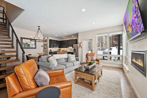 Relax in this stylish living room with a leather sofa, grey couch, and flat-screen TV.