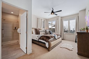 Relax in this serene bedroom with a large bed, ceiling fan, and stunning view of the snowy landscape.