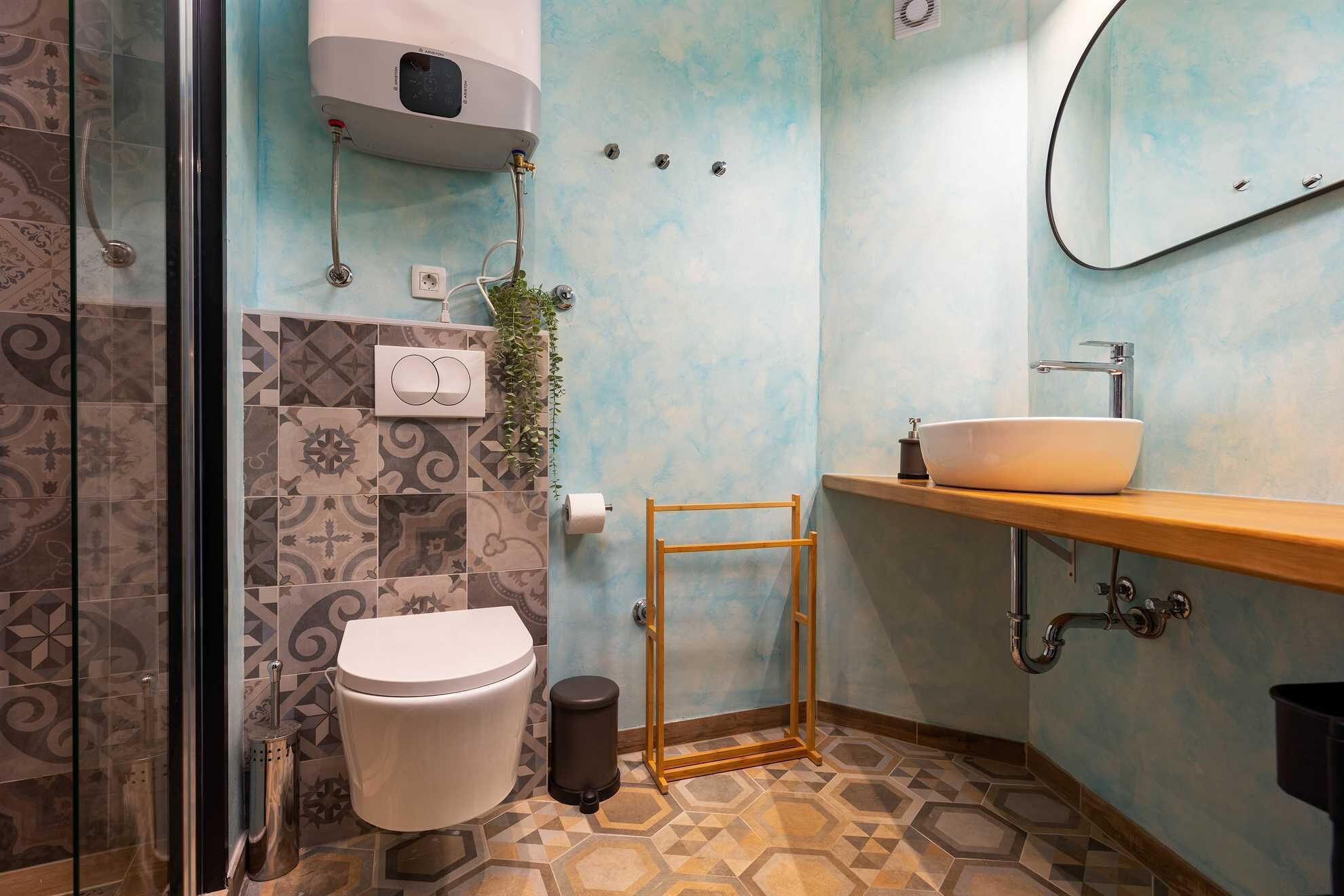 Une salle de bain avec des toilettes, un lavabo et une douche.