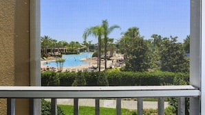 A view of a pool area with palm trees and lounge chairs.