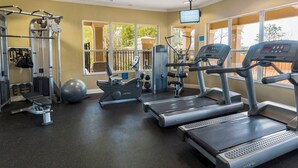 A gym with treadmills, elliptical machines, and weight equipment.