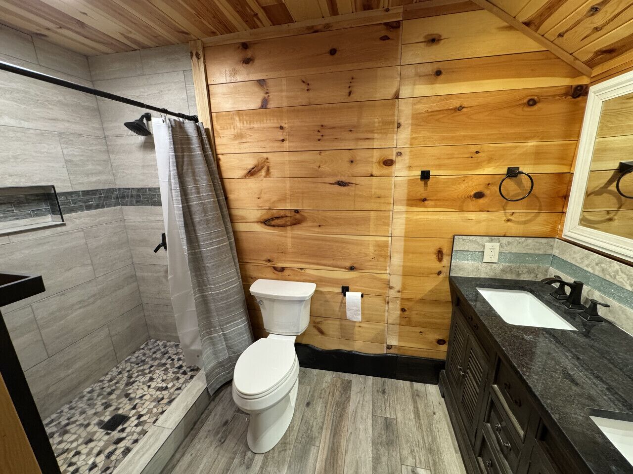 A small bathroom with a shower, toilet, and sink.
