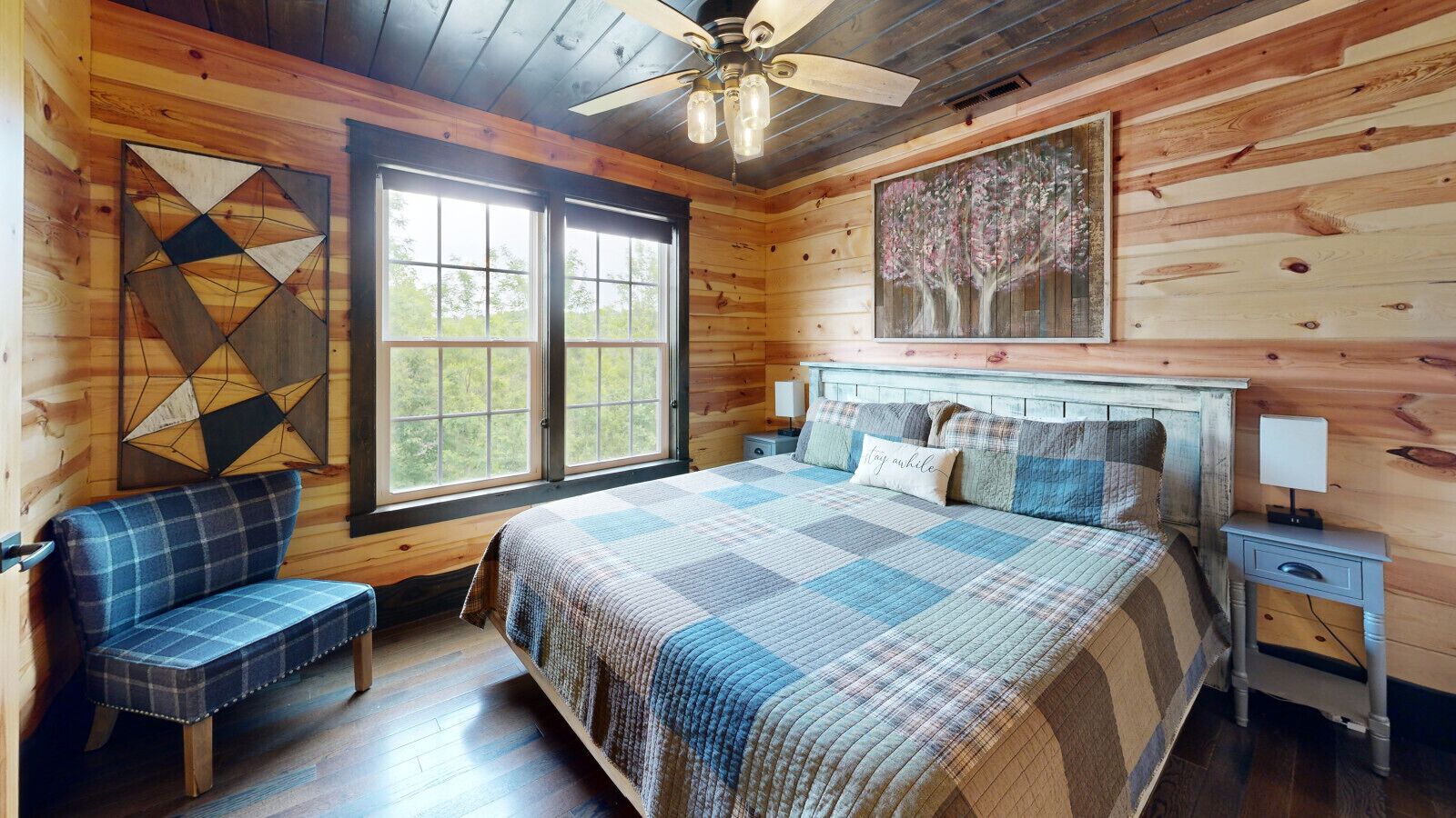 Ein gemütlicher Holzraum mit einem Bett, einer Bank, einem Nachttisch und einem Gemälde.