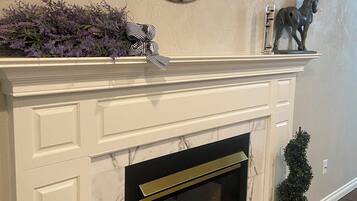 A fireplace with a marble surround, a decorative mirror above it, and a small horse statue on the mantel.
