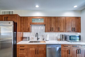 Enjoy cooking in this well-equipped kitchen with a refrigerator, microwave, toaster, and dishwasher.
