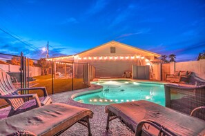 A swimming pool with lounge chairs and a covered area with string lights. - South Scottsdale Poolside Getaway! (Scottsdale)