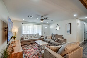Relax in this stylish living room with a large sofa, coffee table, and mounted TV.