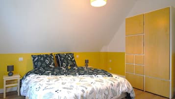 A bedroom with a bed, nightstands, a lamp, and a wardrobe.