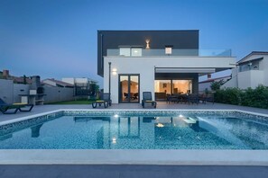 A modern two-story house with a swimming pool in the foreground. - Spacious Villa Elita with Two Heated Pools (Pula)