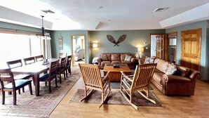 Un salón amplio con comedor, muebles de madera y un ventanal grande.