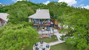 A two-story house with a deck, a fire pit, and a covered outdoor seating area. - Lake views from The Byrd House (Pottsboro)
