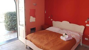 A bedroom with a bed, a nightstand, a mirror, and a window. - Mami Luroviga (Vico Equense)