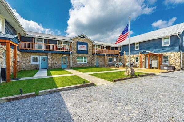 A hotel with a stone facade, a flag, and a well-maintained lawn. - Suite 203 - Felicity at Rock Spring Resort (Rock Spring)
