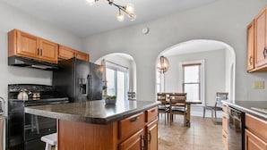A spacious kitchen with wooden cabinets, a large island, and a dining area with a table and chairs.