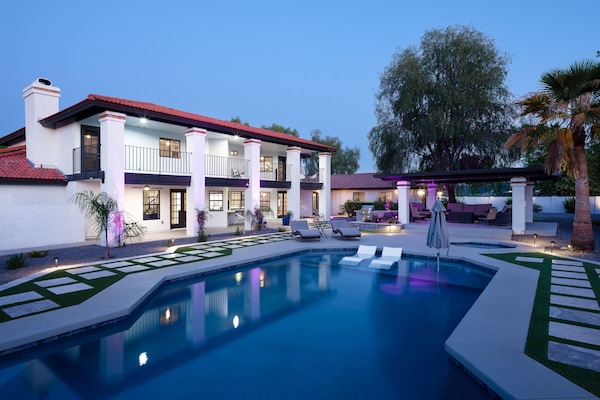 Resort-style backyard with sparkling heated pool & spa, sun loungers, BBQ grill, covered gazebo with multiple lounge areas, outdoor seating, and putting green setup.