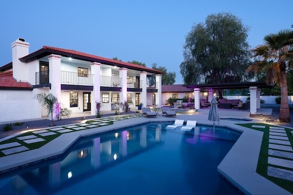 Resort-style backyard with sparkling heated pool & spa, sun loungers, BBQ grill, covered gazebo with multiple lounge areas, outdoor seating, and putting green setup.
