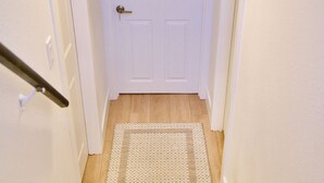 Un escalier avec des marches en bois menant à une porte blanche dotée d’une poignée de porte.