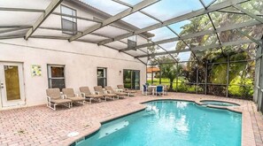 Une piscine couverte avec des chaises longues et un espace patio.