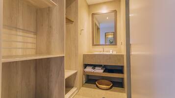 A modern bathroom with a wooden vanity, a large mirror, and a built-in sink.