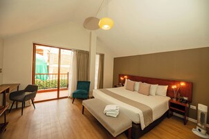 Een hotelkamer met een groot bed, een bureau, een stoel en een bank.